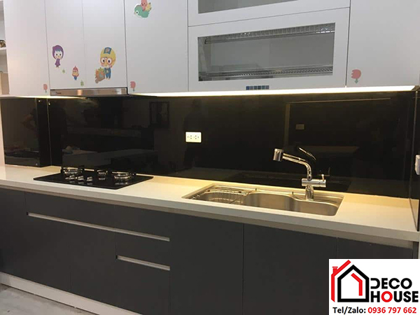 Mẫu kính bếp đẹp với sự kết hợp giữa kính đen và đèn led vàng nhẹ.